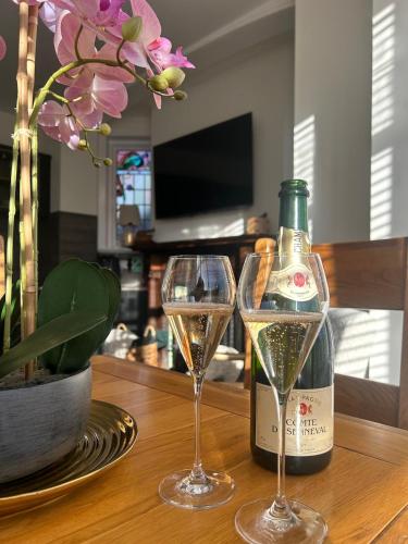 two glasses of champagne on a table with a bottle of wine at The Magnolia in Rhôs-on-Sea