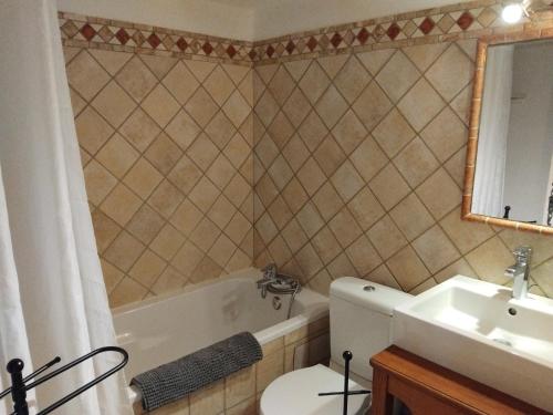 une salle de bain avec une baignoire, un lavabo et des toilettes dans l'établissement Les Flamants, 180 m de la Plage, à Saintes-Maries-de-la-Mer