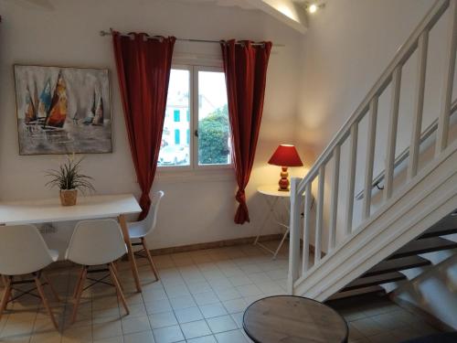 un salon avec une table et des chaises et une fenêtre dans l'établissement Les Flamants, 180 m de la Plage, à Saintes-Maries-de-la-Mer