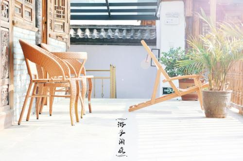 a group of chairs sitting on a porch at Tourist Courtyard Hotel in Jianchuan