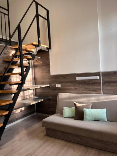 a living room with a couch and a staircase at Centrum Rezidencia Pápa in Pápa