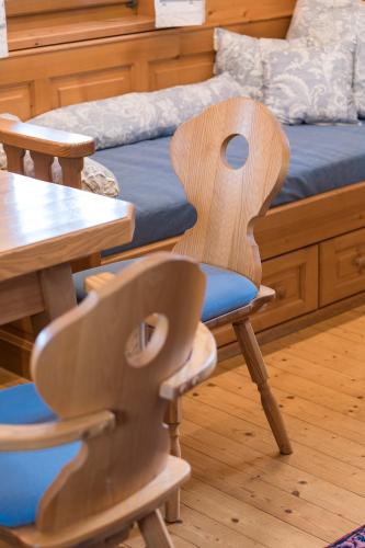 a wooden chair sitting next to a table and a bed at SCHILCHERLANDLEBEN - Weingartenhaus in Sankt Stefan ob Stainz