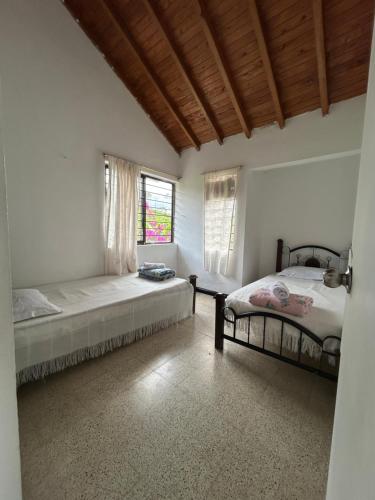 a bedroom with two beds and a window at Finca con espectacular zona verde y hermosa vista a la piedra in Guatapé