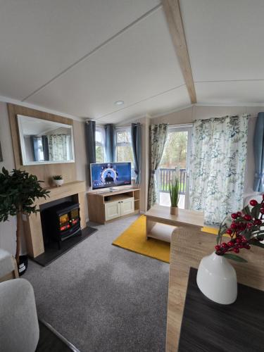 a living room with a fireplace and a tv at Durdle Door family Holiday Home in West Lulworth
