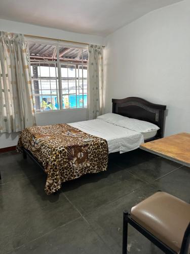 a bedroom with a bed with a leopard print blanket at El Patriarca Hotel in Sasaima