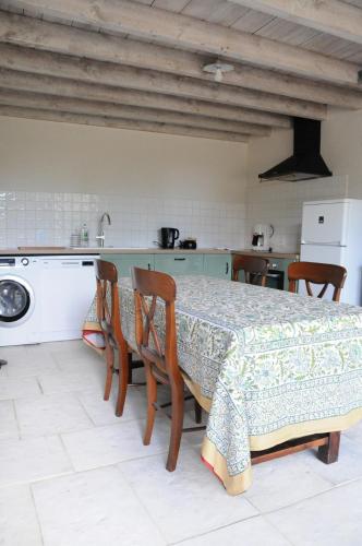 - une cuisine avec une table, des chaises et un évier dans l'établissement Les Berthiers - région des châteaux et des vignes, à Sepmes