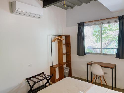 a bedroom with a bed and a desk and a window at ESO Santa Teresa in Santa Teresa Beach