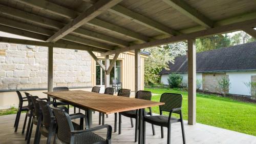 a wooden table and chairs on a patio at Sandstone Lodge in Kacanovy