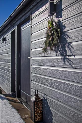 a door to a garage with a wreath and a lantern at Chata Idylka - Nová chata se zahradou in Loučná nad Desnou