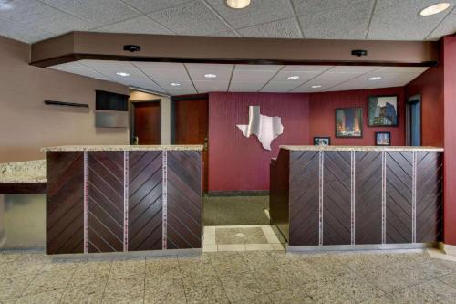 a lobby with purple walls and wooden lockers at Heritage Inn Suites Houston Sugar Land, Trademark by Wyndham in Sugar Land