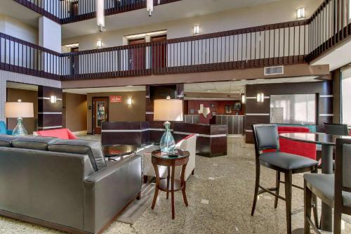 a hotel lobby with couches and tables and chairs at Heritage Inn Suites Houston Sugar Land, Trademark by Wyndham in Sugar Land