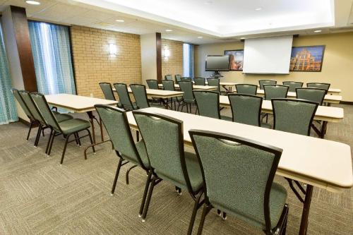 a conference room with tables and chairs and a screen at Heritage Inn Suites Houston Sugar Land, Trademark by Wyndham in Sugar Land