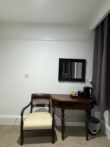 a room with a table and a chair and a mirror at Juniper Berry in Southampton