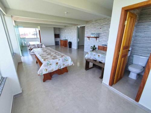 a large room with two beds and a toilet at Pousada Pegadas na Areia in Palhoça