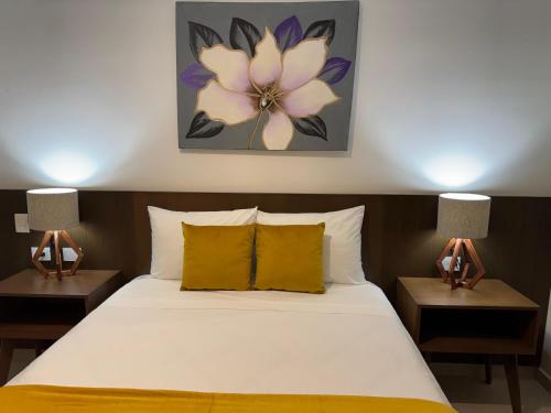 um quarto com uma cama com 2 candeeiros nas mesas em Hotel Faava em Mazatlán
