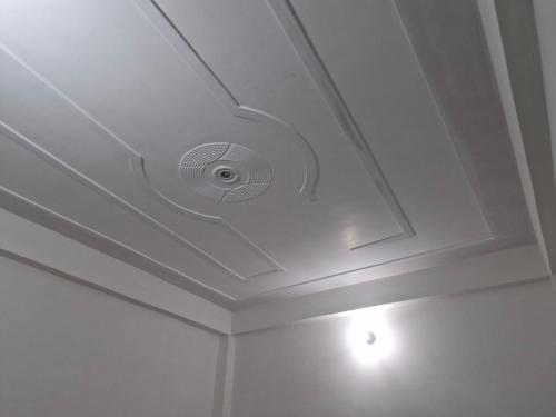 a white coffered ceiling with a smoke detector on it at Triveni Darshan Homestay in Jhūsi