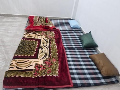 a bed with a red blanket on top of it at Triveni Darshan Homestay in Jhūsi