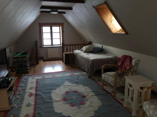 a attic room with a bed and a rug at Torpet in Tollarp