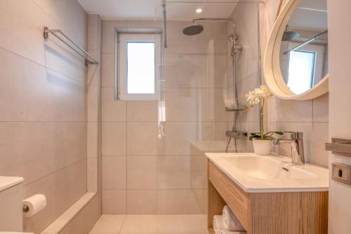 a bathroom with a sink and a shower and a mirror at Sea Daffodil apartments in Kissamos