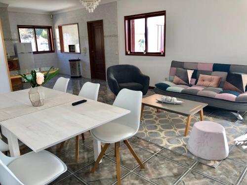 a living room with a table and chairs and a couch at Catloc & Kitcat Alojamento Local in Costa de Além