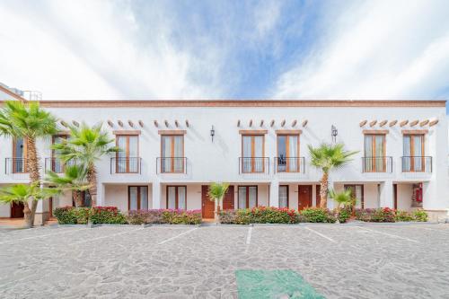 a large white building with palm trees in front of it at Seven Crown La Paz Centro Historico in La Paz