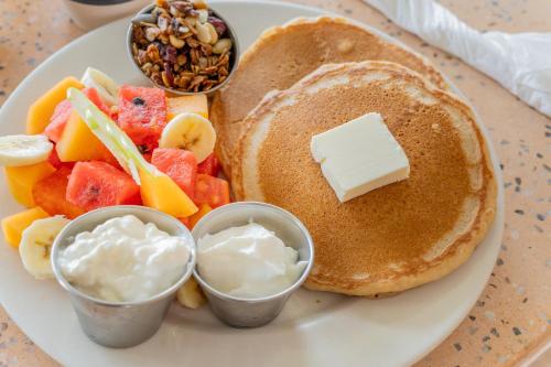 een wit bord met pannenkoeken, fruit en dipsaus bij Seven Crown La Paz Centro Historico in La Paz