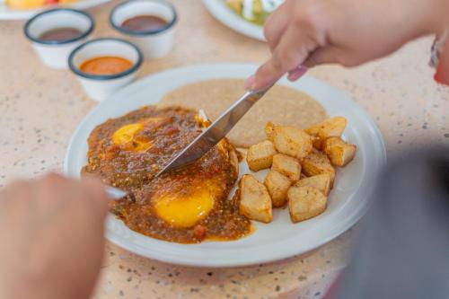 een persoon die een bord eten snijdt met een mes bij Seven Crown La Paz Centro Historico in La Paz