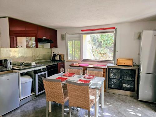une cuisine avec une table et des chaises dans une cuisine dans l'établissement T2 en Rez-de-jardin Fleur de Sel, à Saint-Raphaël