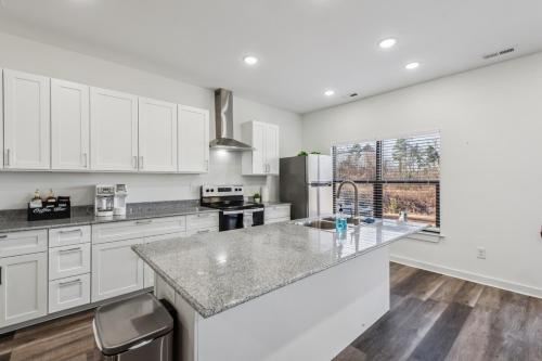 a kitchen with white cabinets and a large counter top at Pet Friendly 3BR House in Charlotte in Charlotte