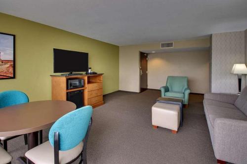 a room with a couch and a table and chairs at Heritage Inn Suites Houston Sugar Land, Trademark by Wyndham in Sugar Land