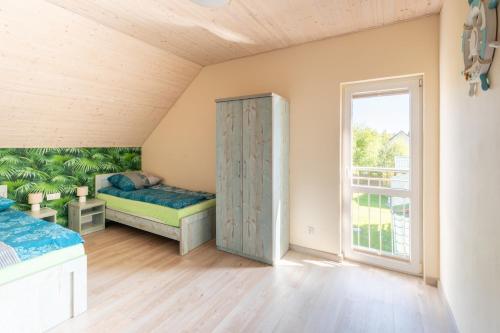 a bedroom with two beds and a window at Morski domek in Dębki