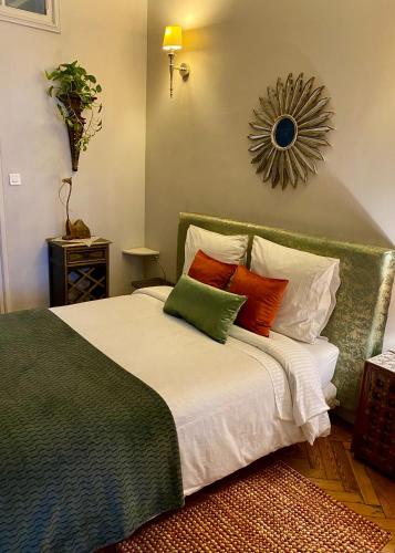 une chambre avec un grand lit avec des oreillers colorés dans l'établissement A La Fleur d Oranger - Lille La Madeleine, à La Madeleine