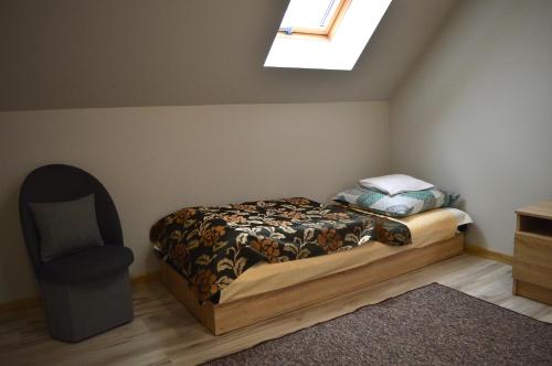a bedroom with a bed and a chair in it at Gajówka in Wünschelburg
