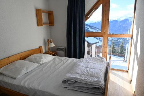 une chambre avec un lit et une grande fenêtre dans l'établissement Résidence Petite Ourse A - Appartement 2 pièces 7 personnes à Vallandry proche des pistes MAE-2012, à Peisey-Nancroix
