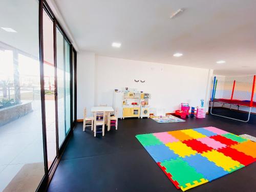 a room with a colorful rug on the floor at Pé na Areia, Piscina Borda Infinita, Vaga de Garagem, Portaria 24 hs in Salvador