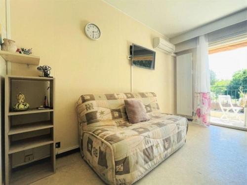 une chambre avec un lit et une horloge au mur dans l'établissement Gréoux-les-bains Studio fonctionnel proche thermes, à Gréoux-les-Bains