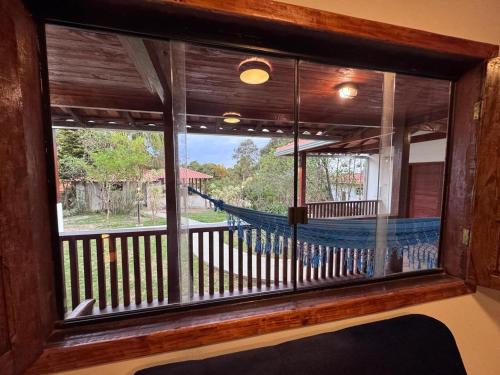 a window in a room with a view of a hammock at Pousada Kokopelli in Lavras Novas