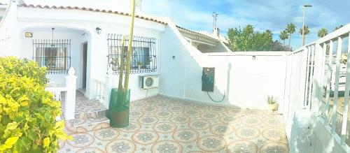 a white house with a courtyard with a tile floor at El Rincón de Sotillo beach in Los Alcázares