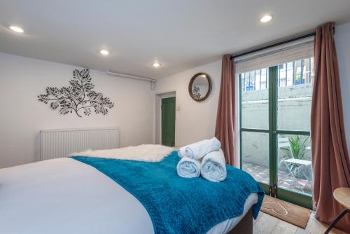 a bedroom with a bed with towels on it at Chic 1-bed Garden Flat, London, Convenient for Tower Bridge, Great Public Transport in London