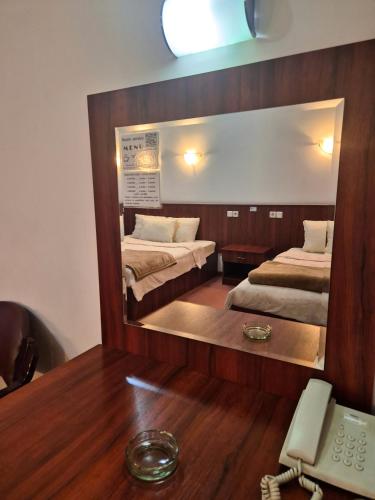 a mirror in a room with two beds and a phone at Vila Oxa in Novi Pazar