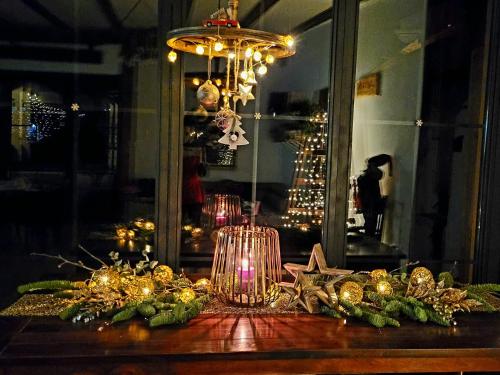 a table with a chandelier and christmas decorations on it at Joyard - Pensiune & Parc in Porumbacu de Sus