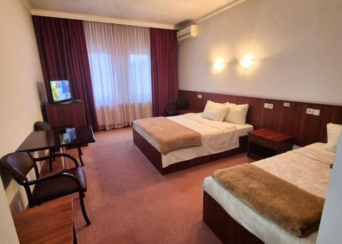 a hotel room with two beds and a television at Vila Oxa in Novi Pazar