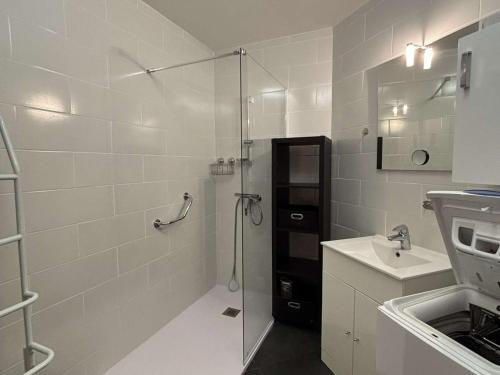 une salle de bain blanche avec une douche et un lavabo dans l'établissement Appartement Confortable proche Thermes avec Balcons et Climatisation à Balaruc-les-Bains - FR-1-503-3, à Balaruc-les-Bains