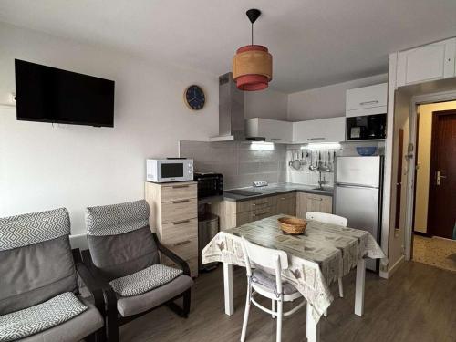 une cuisine avec une table et deux chaises et une cuisine avec une table dans l'établissement Appartement climatisé, Wifi, Animaux admis, Parking, proche thermes - FR-1-503-102, à Balaruc-les-Bains