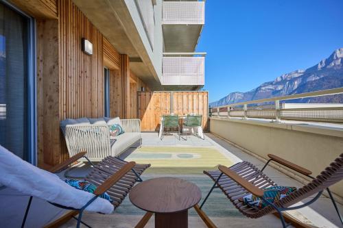 a balcony with chairs and a couch and a table at Le Miroir De Saint-Jacques in Sallanches