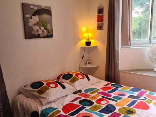 une chambre avec un lit avec une courtepointe colorée dessus dans l'établissement Charmant T2 avec balcon, animaux admis, près des thermes - FR-1-503-153, à Balaruc-les-Bains