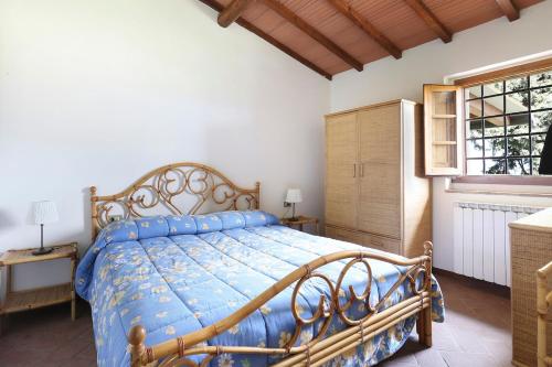 a bedroom with a bed with a blue comforter at Casa di Romano - La Loggia in Marcialla