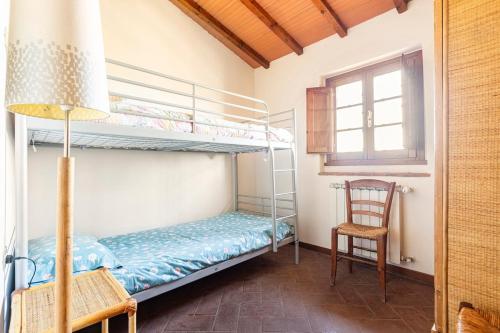 a bedroom with two bunk beds and a chair at Casa di Romano - La Loggia in Marcialla