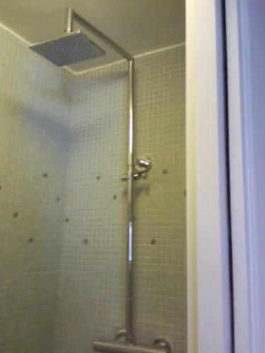 une douche dans une salle de bain avec une porte vitrée dans l'établissement Studio en plein cœur de Paris, à Paris