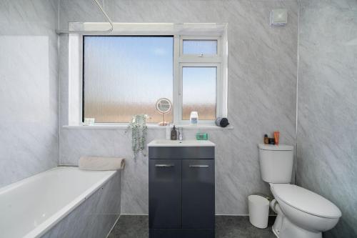 a bathroom with a toilet and a sink and a bath tub at Disc-counts For Family & Work stays, Coffee machine - Fast wifi - Free parking - Private Garden in Borehamwood